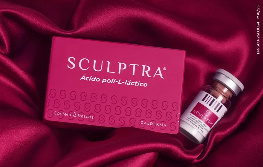 A imagem mostra uma embalagem e um frasco do produto Sculptra®, um bioestimulador de colágeno, dispostos sobre um tecido de cetim vermelho-escuro. A embalagem rosa vibrante exibe o nome 